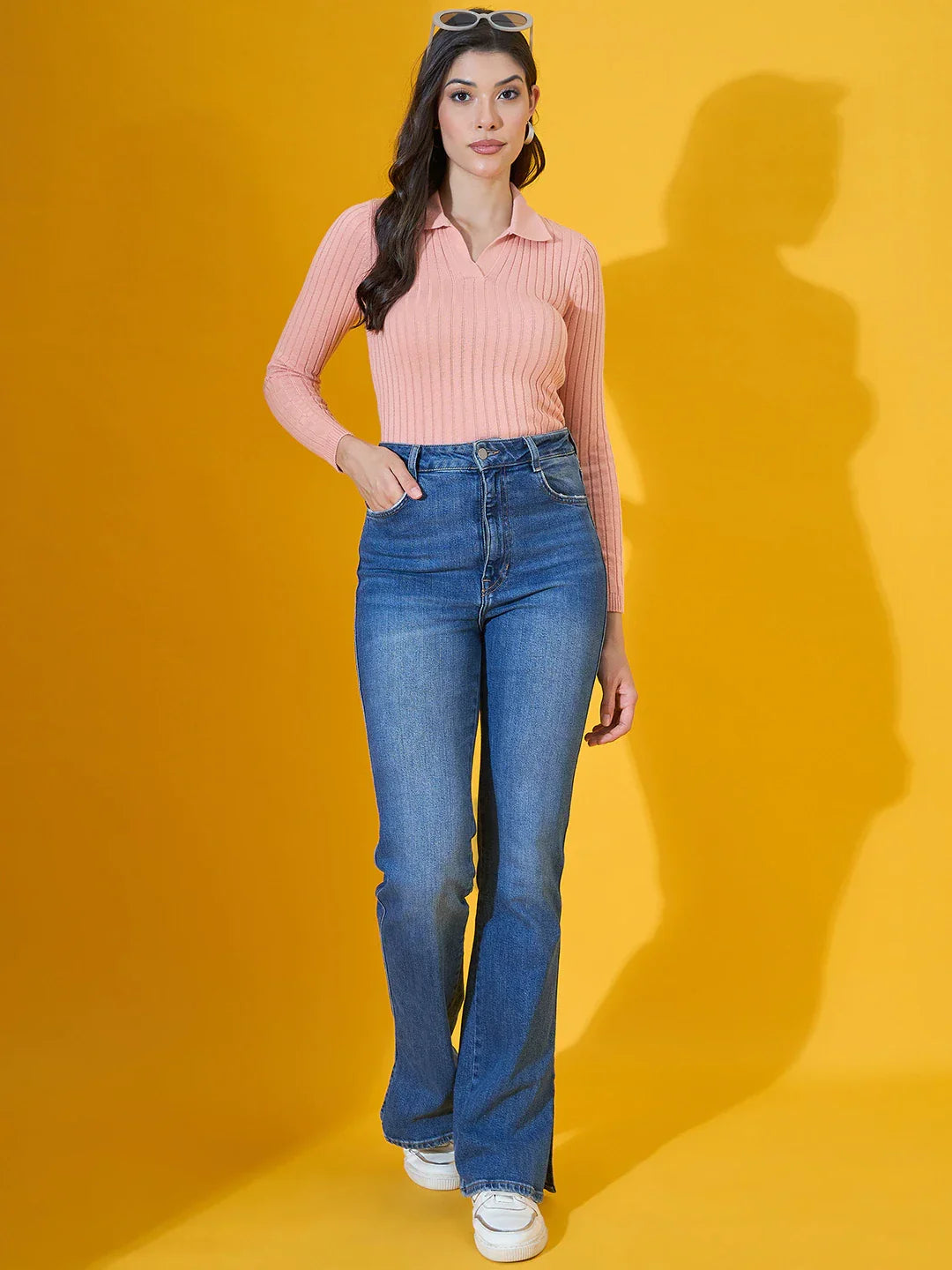 Woman wears 98degreenorth’s salmon ribbed collar neck sweater, slim fit knitwear, with blue jeans and white sneakers.