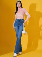 Woman in a 98degreenorth salmon ribbed turtleneck sweater, blue jeans, white shoes, sunglasses, and a small white purse.