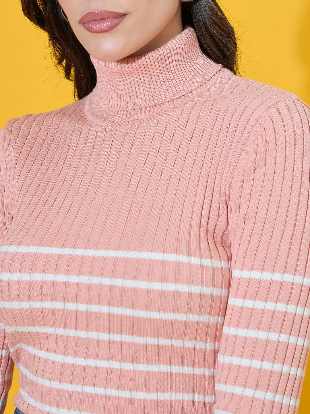 Woman in 98degreenorth Women's Salmon Ribbed Turtleneck Sweater, winter fashion, on a yellow background.