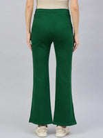 Model in 98degreenorth Women’s Smiley Green Flared Bootcut Sweatpants with Side Slit, back view on gray.