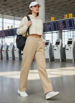 Woman in 98degreenorth camel melange fleece sweatpants walks through airport with black backpack.