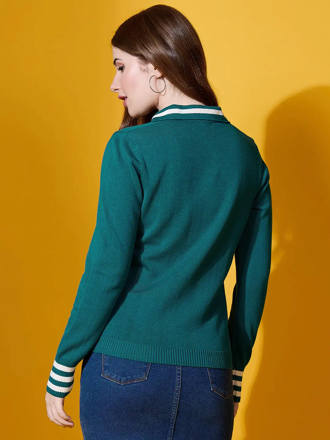 Woman with long brown hair wears the 98degreenorth Women’s Teal Striped Collar Knit Sweater, facing away on yellow.