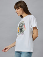 Woman in a 98degreenorth Women’s Typography Cotton T-shirt, streetwear style, standing sideways on a gray background.