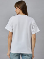 A woman with straight brown hair wears a 98degreenorth Typography Cotton T-shirt, streetwear style, facing away.