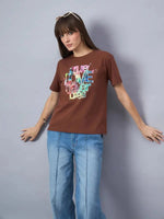 Woman in sunglasses wearing 98degreenorth Women’s Typography Graphic Print Cotton Tee, posing by a gray backdrop.