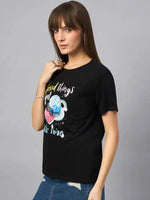 Woman wears 98degreenorth Women’s Typography Printed Cotton Tee and blue jeans, standing against a gray background.