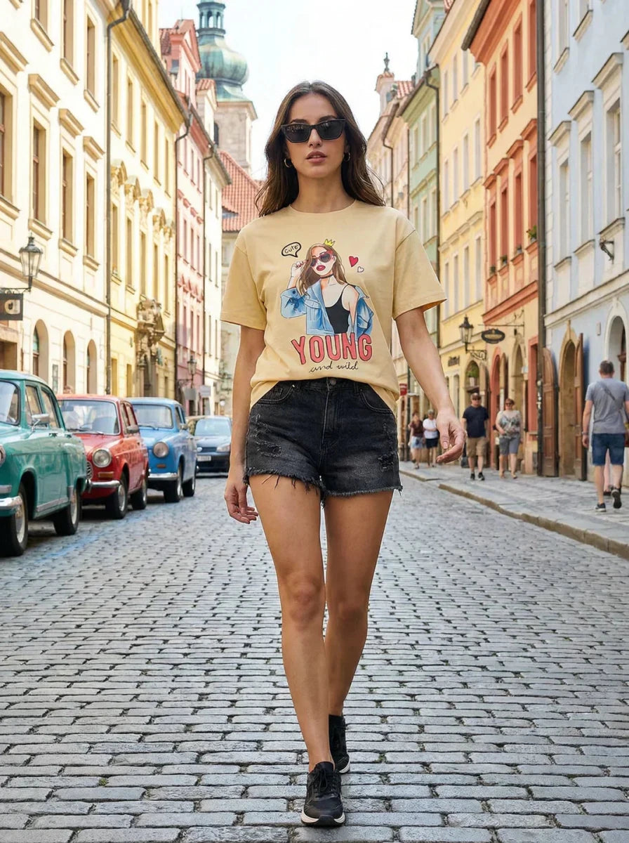 A woman in sunglasses and a 98degreenorth Women’s Typography Printed Oversized T-shirt walks down a vibrant street.