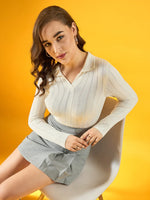 Woman with wavy brown hair in a 98degreenorth Women’s White Ribbed Collar Sweater sits on a chair, yellow background.