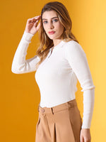 Woman in 98degreenorth's white ribbed collar zipper sweater, slim fit knitwear, and tan pants against a yellow background.
