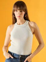 Woman in 98degreenorth’s white ribbed halter neck knit top and blue jeans, standing against a yellow background.
