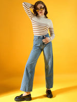 Woman in 98degreenorth white ribbed striped turtleneck sweater poses confidently against a yellow background.