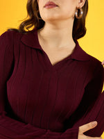 Woman in a 98degreenorth Women's Wine Ribbed Collar Sweater, standing against a yellow background, wearing hoop earrings.